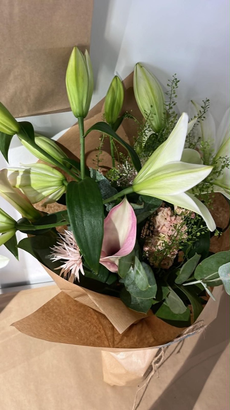 Buket med hvide liljer og calla i gavepapir